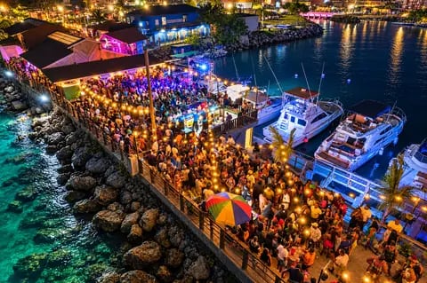 Festa noturna em píer iluminado à beira-mar
