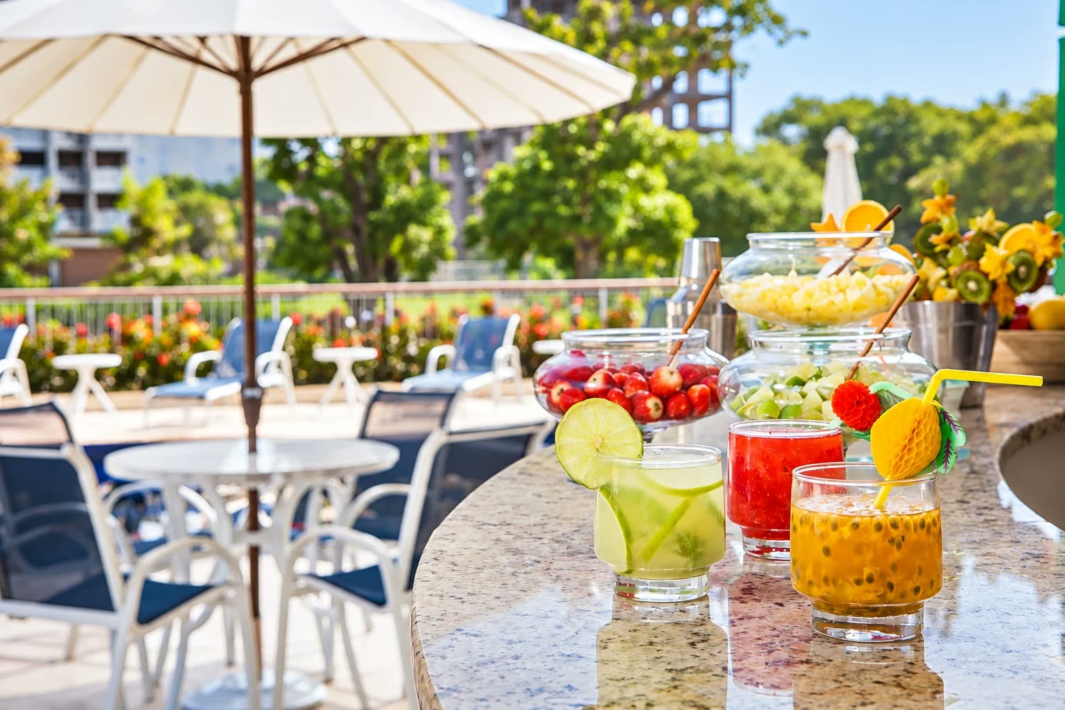 Drinques de frutas no balcão do bar, com mesas e cadeiras ao fundo