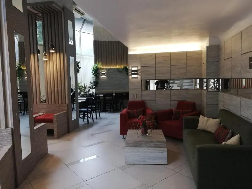Lounge do Hotel Montecarlo Santiago com sofás e iluminação suave