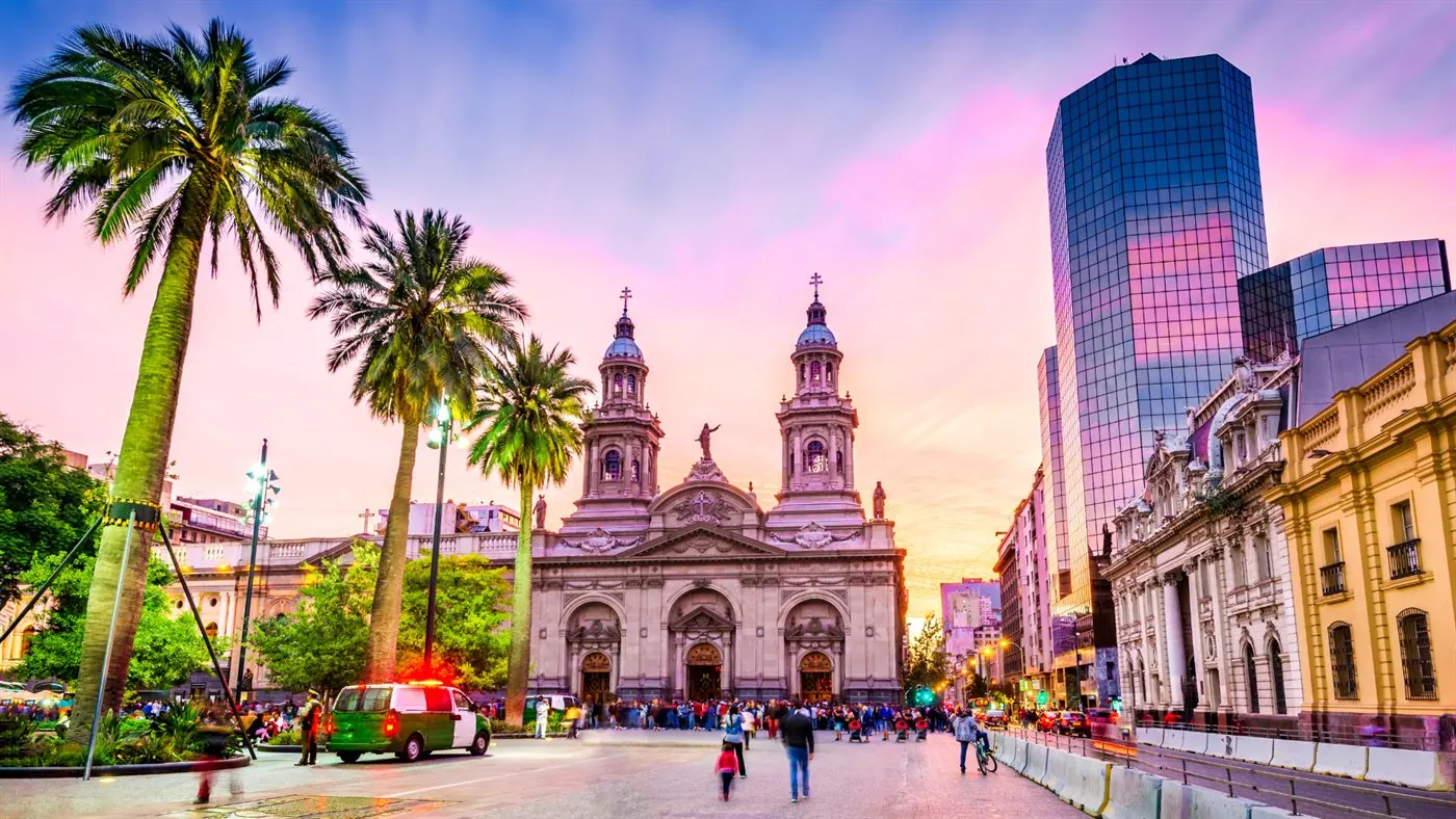Plaza de Armas com palmeiras e a Catedral Metropolitana de Santiago ao entardecer