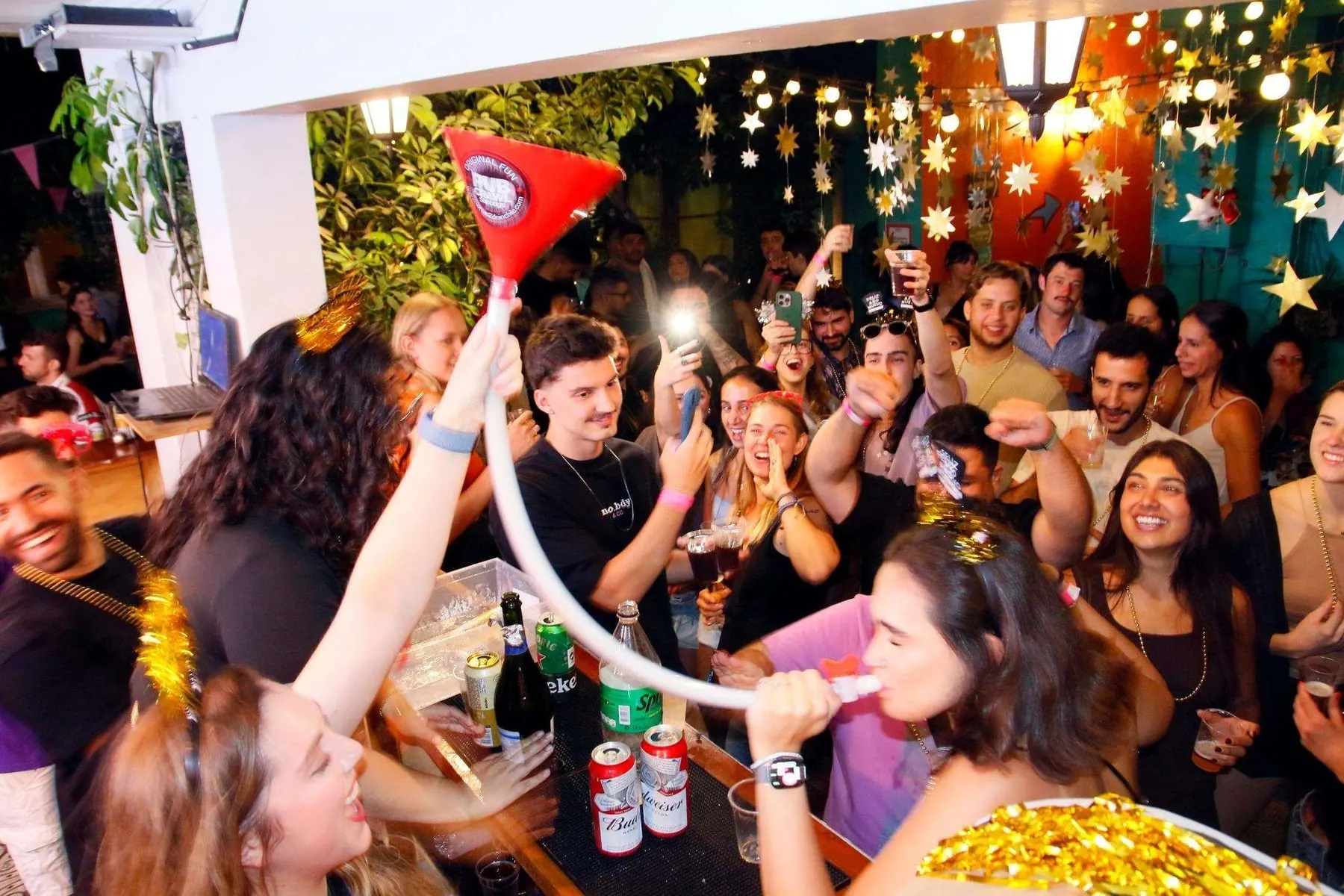 Grupo animado em um bar decorado com luzes e estrelas durante o Pub Crawl em Santiago